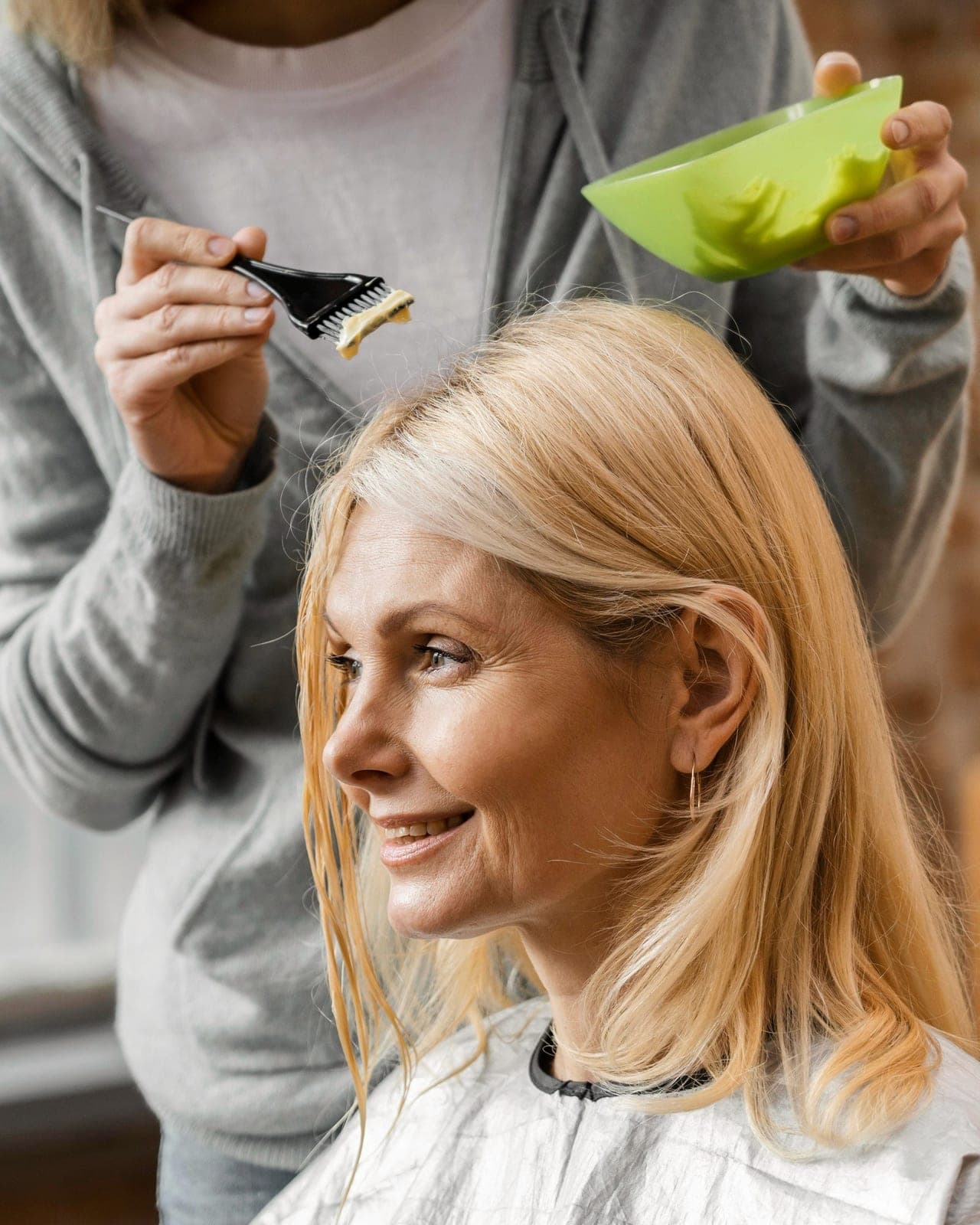 Haarfarbe wird Strähne für Strähne mit dem Färbepinsel aufgetragen